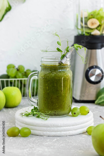 Green vitamin smoothie with shoots of young peas. Green smoothie made from apple, grape and kiwi 
