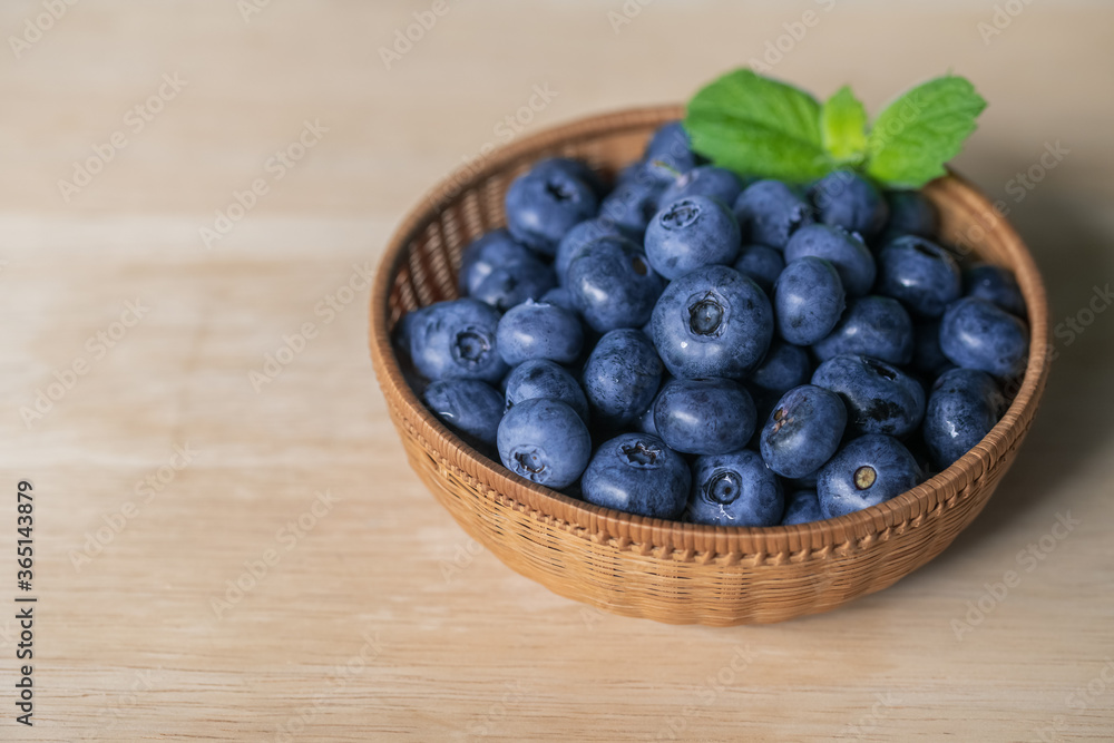 Fresh ripe blueberries in basket on wooden background.
Fresh ripe blueberries in basket on wooden background.