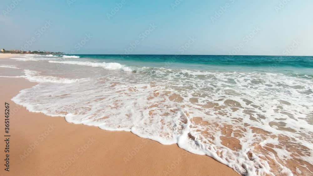 Wide slow motion shot. Big ocean waves crashing on a sandy tropical beach of Sri Lanka. Wide slow motion shot. Big ocean waves crashing on a sandy tropical beach of Sri Lanka.