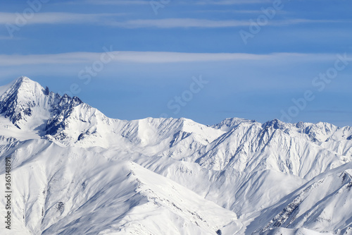 High snowy mountains and blue sky with clouds