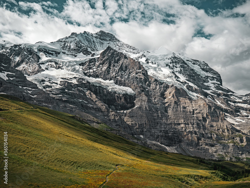 Panoramic shot of the harsh rock textures and stunning alpine glacier landscape of the Jungfrau region of Swiss Alps.