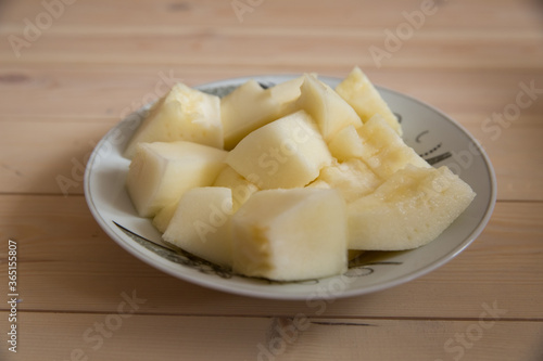 Melon slice on wooden plate with wooden background . On a wooden background in a white plate of Sliced melon .