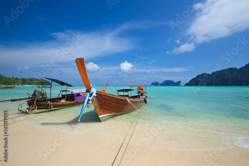 photo taken on a wide angle lens, thai fishing boats on the azure sea on the bounty beach in thailand, clear sea, picturesque island, paradise enjoyment, travel and vacation, background for postcards © Aleksandr Lavrinenko