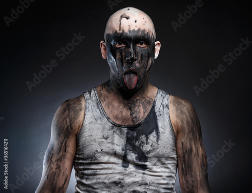 Photo of bald mad man with dirty make-up and tongue