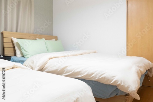 Twin bed and blanket in a small bedroom for couple people