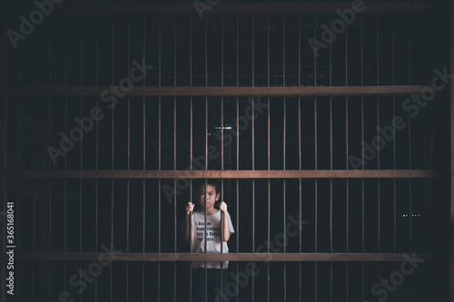 Asian little boy arrested in old and dark prison with concept
