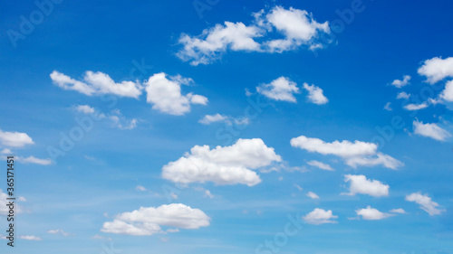 Many blurred white clouds on the beautiful blue sky for use as a background image.