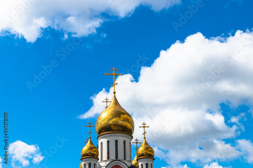 Golden domes of christian church in Moscow. Beautiful blue sky background.