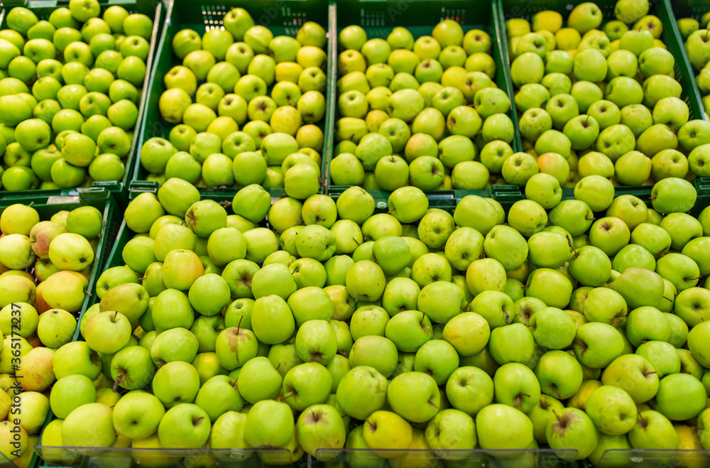 fruits, harvest, food and sale concept - green apples at grocery store or market