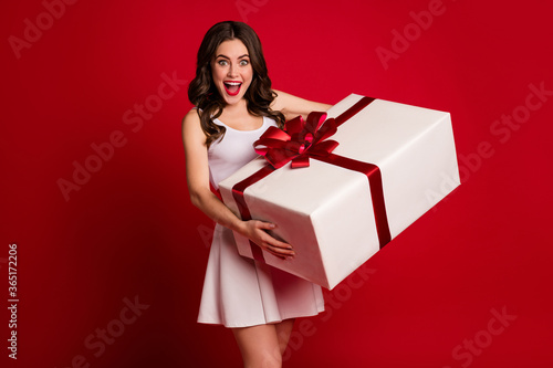 Portrait of her she nice attractive pretty cheerful cheery glad wavy-haired girl carrying big white giftbox isolated on bright vivid shine vibrant red burgundy marsala maroon color background