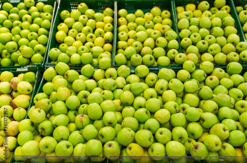 fruits  harvest  food and sale concept - green apples at grocery store or market