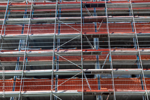 architecture and urban concept - multi-storey building under construction with scaffolding