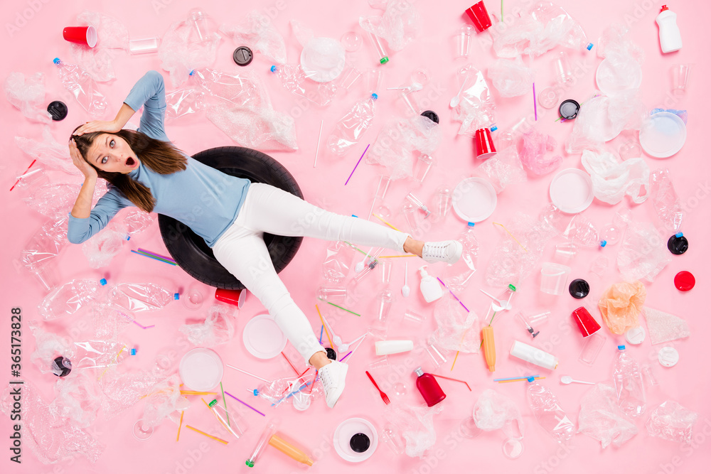 Top above high angle view full size photo crazy anxious girl sit swim tire water ocean dirty plastic bags cup disposal bottle glass touch hands head flat lay isolated pastel color background