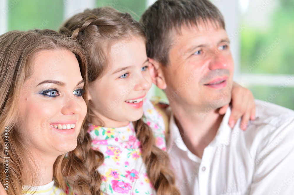 Happy parents and daughter posing in room Happy parents and daughter posing in room