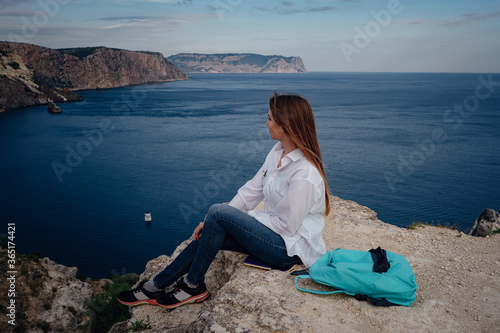 Woman above cold sea on cliff alone. Travel Lifestyle concept