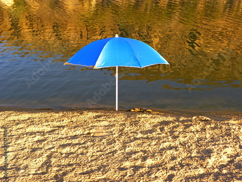 Blue umbrella on the beach near the river Sisandro  Portugal.