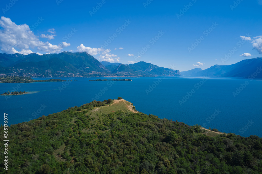 Lake Garda, Italy. Aerial view of punta sasso, rocca di manerba in the background mountains, garda island at high altitude