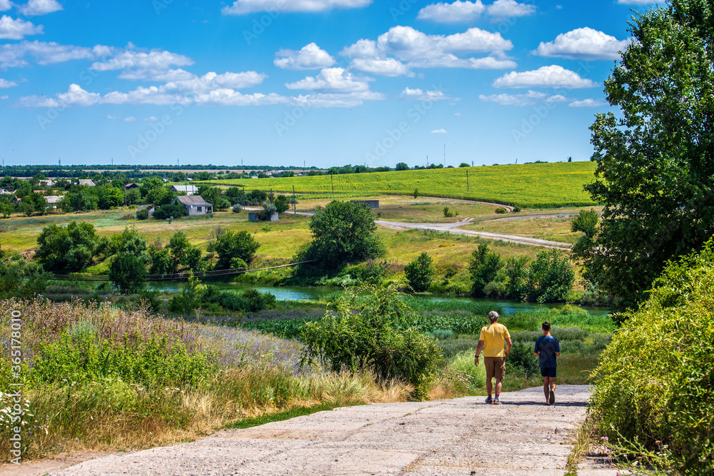Fototapeta premium Rural landscape. People are coming. Road to the village Nedayvoda, Ukraine.