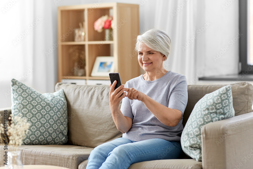 technology, communication and people concept - happy smiling senior woman with smartphone at home technology, communication and people concept - happy smiling senior woman with smartphone at home