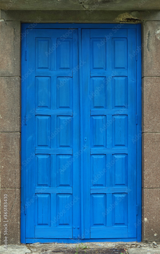 Old wooden door painted acid blue color