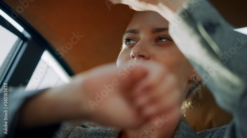 Beautiful business woman dancing in car. Female professional celebrating victory