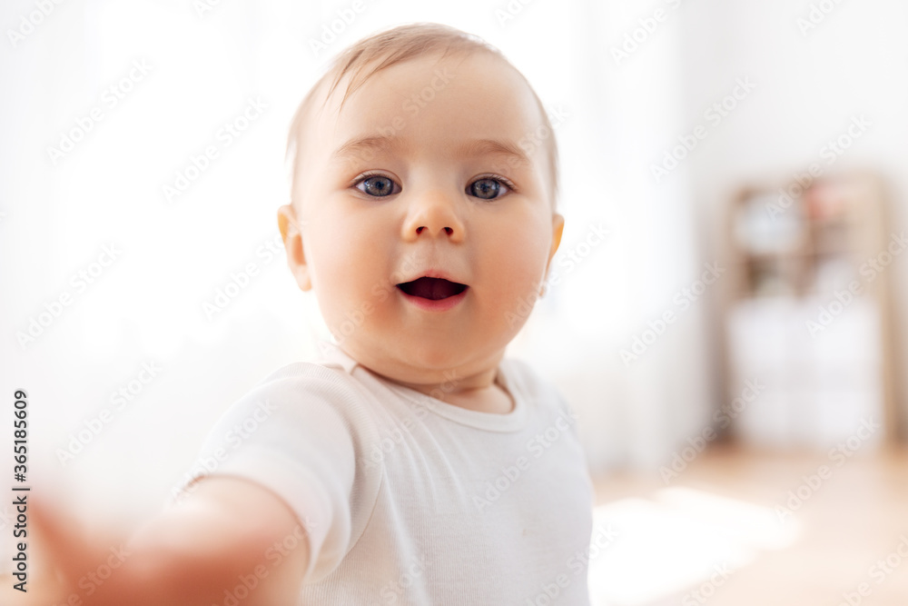 childhood and people concept - portrait or selfie of little baby at home