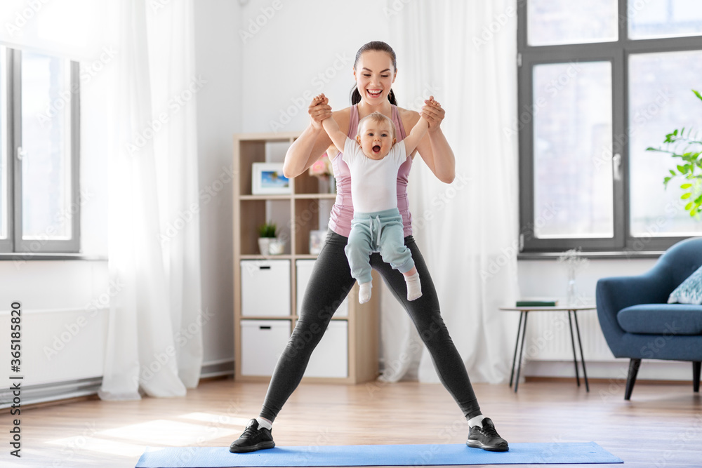 Obraz premium family, sport and motherhood concept - happy smiling mother with little baby exercising at home
