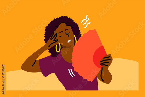 Mental stress, heat, dehydration, inconvenience concept. Stressed exhaustion annoyed young woman sitting on sofa using waving fan suffering from overheating in summer. Absence air conditioner at home.