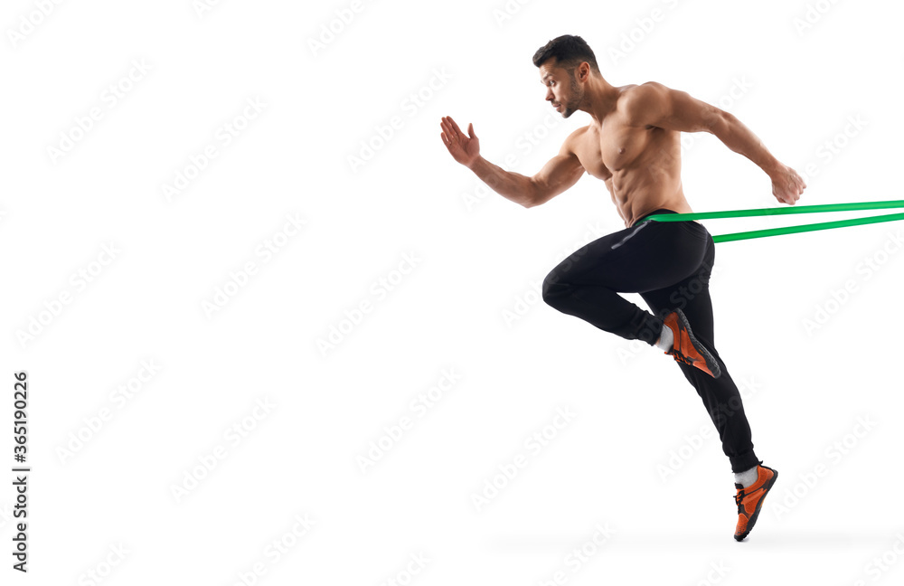 Obraz premium Shirtless bodybuilder running using resistance band.