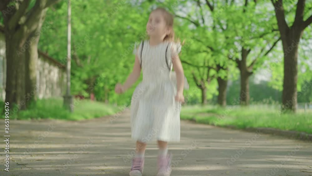 Cheerful Caucasian girl spinning and jumping in sunny summer park. Wide shot portrait of pretty little brunette child enjoying good weather outdoors. Leisure, lifestyle, childhood, happiness. Cheerful Caucasian girl spinning and jumping in sunny summer park. Wide shot portrait of pretty little brunette child enjoying good weather outdoors. Leisure, lifestyle, childhood, happiness.