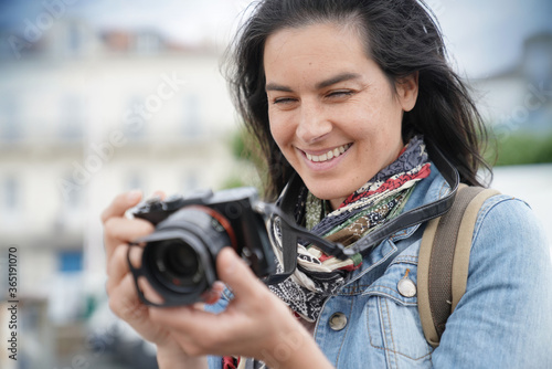 Obraz na plátně Portrait of woman reporter taking pictures with reflex camera