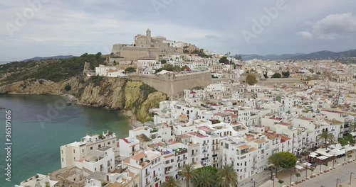 Awsome aerial fotage of Ibiza, Spain old town buildings and castle. Drone flies backward