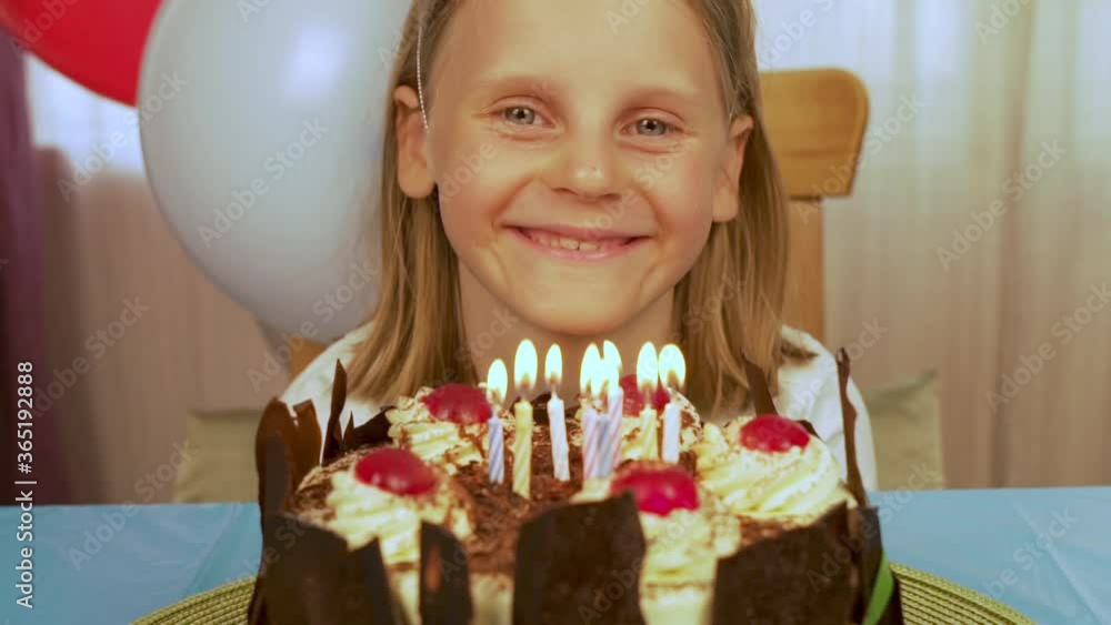 Portrait of a Happy Smiling Laughing Child in front of a Birthday Cake with Lighted Candles. The Concept Of The Birthday Celebration Portrait of a Happy Smiling Laughing Child in front of a Birthday Cake with Lighted Candles. The Concept Of The Birthday Celebration