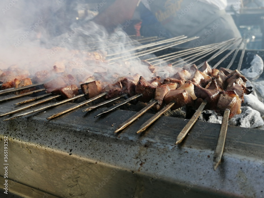 Shashlik preparing on a barbecue grill over charcoal. Shashlik or Shish kebab popular in Eastern Europe. Shashlik preparing on a barbecue grill over charcoal. Shashlik or Shish kebab popular in Eastern Europe.