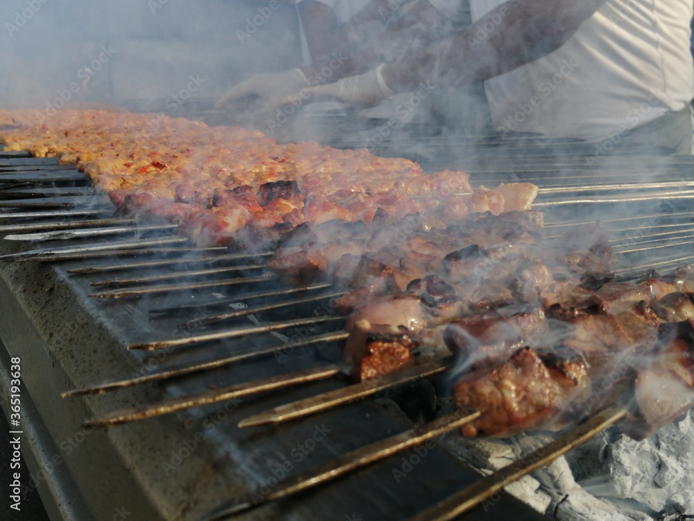 Shashlik preparing on a barbecue grill over charcoal. Shashlik or Shish kebab popular in Eastern Europe. Shashlik preparing on a barbecue grill over charcoal. Shashlik or Shish kebab popular in Eastern Europe.