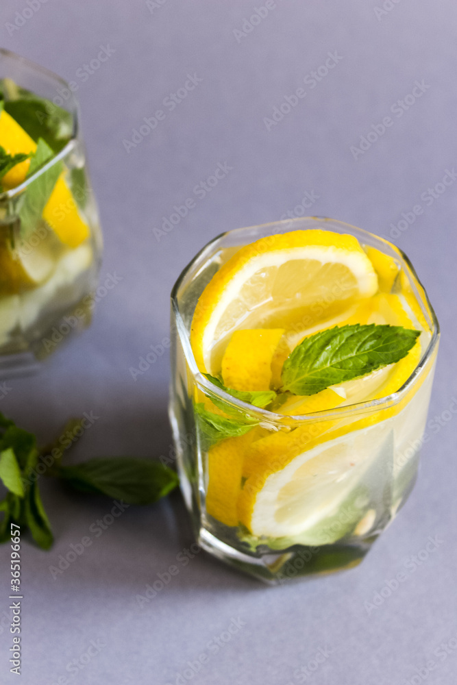 Homemade refreshing summer lemonade drink with lemon slices and mint in glass Homemade refreshing summer lemonade drink with lemon slices and mint in glass