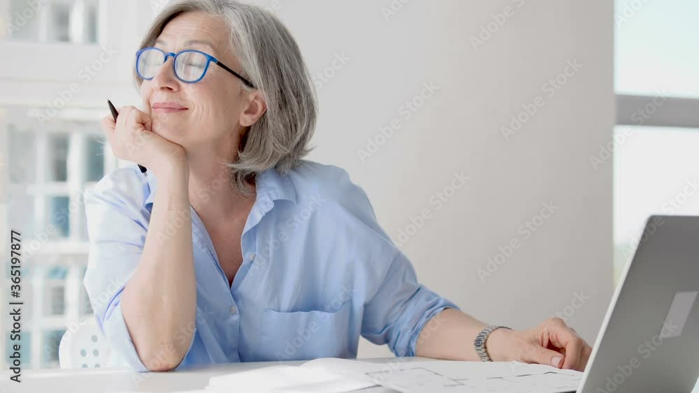 Happy senior lady enjoying break at work table, inspired by favorite job smiling Happy senior lady enjoying break at work table, inspired by favorite job smiling