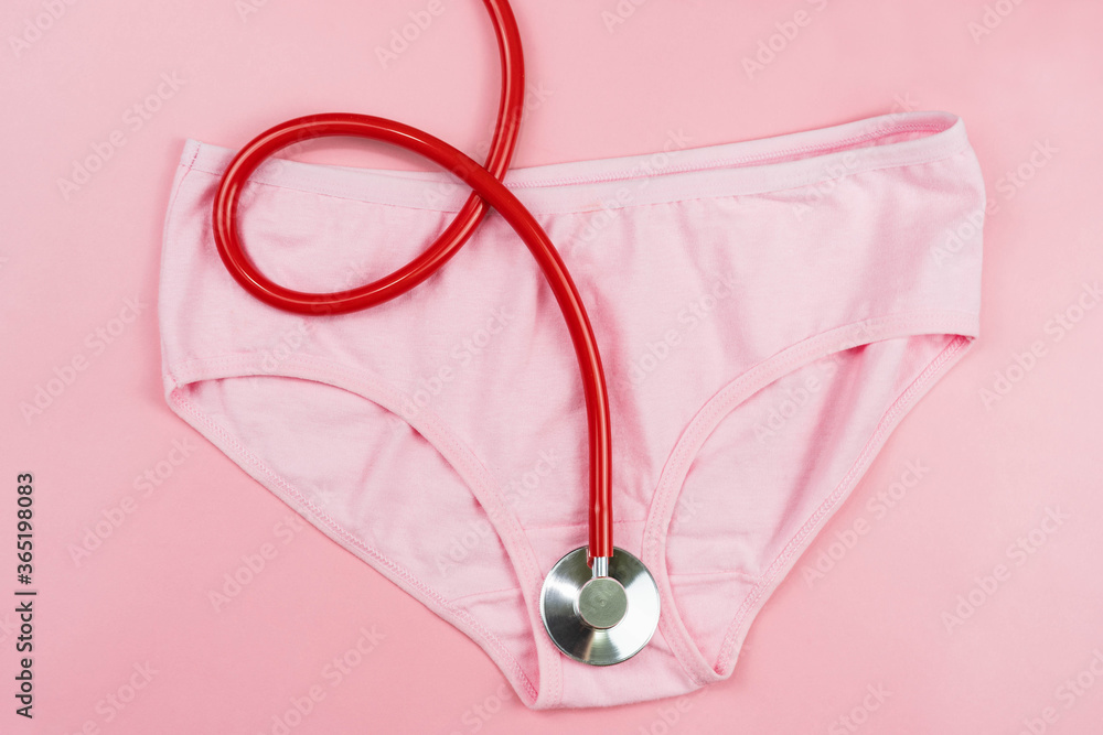 Fototapeta premium Pink underpants and red stethoscope isolated on pink background.Woman hygiene, Concept of sanitary pad,critical days, menstruation,health care