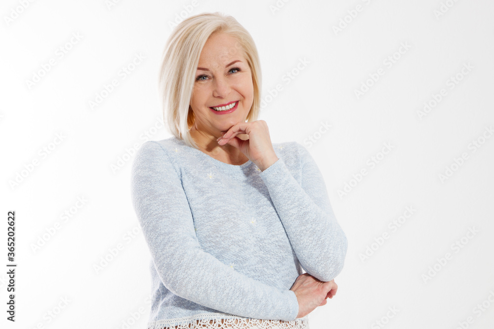 Happy beautiful close up portrait middle age blonde woman. Mid aged healthy female isolated on white background with copy space. Menopause and healthcare. Mature lady wrinkled face. Folded hands