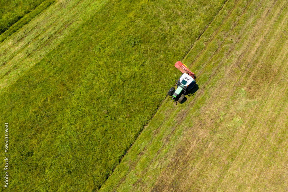 Aerial view of the tractor mowing the grass