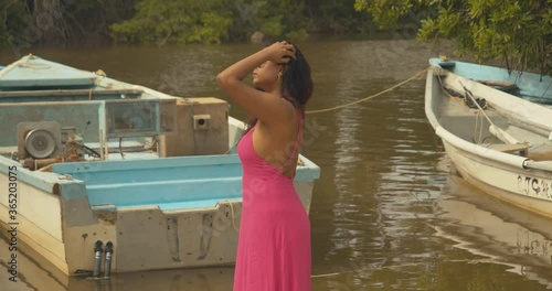 Epic videoshoot in a lagoon with fishing boats in the background of this east indian Caribbean model photo