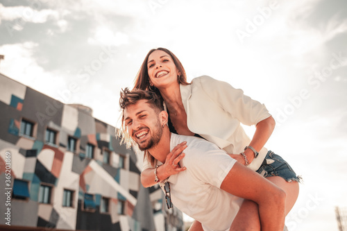Tableau sur toile Ragazza bella e attraente sorride giocando sulle spalle del suo uomo mentre sono