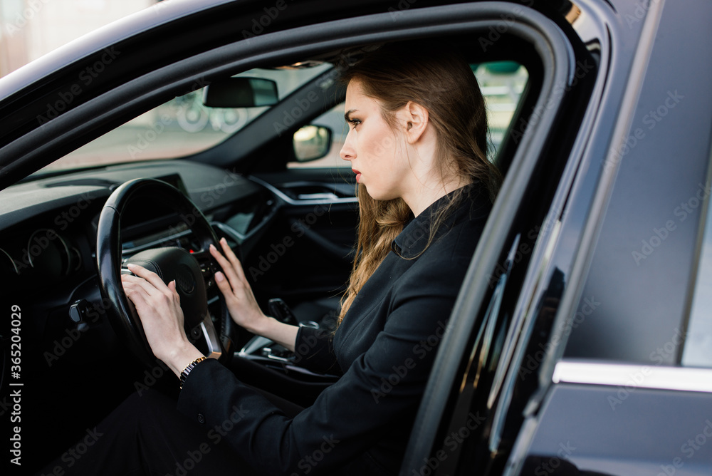 Young businesswoman in black wear with a expensive car Young businesswoman in black wear with a expensive car