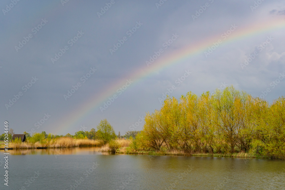 Rainbow in cloudy sky, landscape Rainbow in cloudy sky, landscape