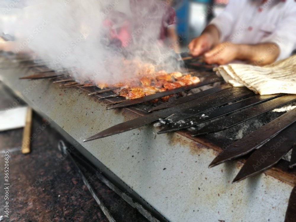 Shashlik preparing on a barbecue grill over charcoal. Shashlik or Shish kebab popular in Eastern Europe. Shashlik preparing on a barbecue grill over charcoal. Shashlik or Shish kebab popular in Eastern Europe.