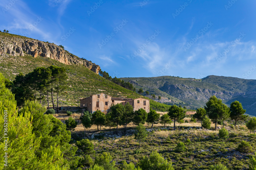 Abandoned farmhouse in the mountains in a sunny day in Alcoy.