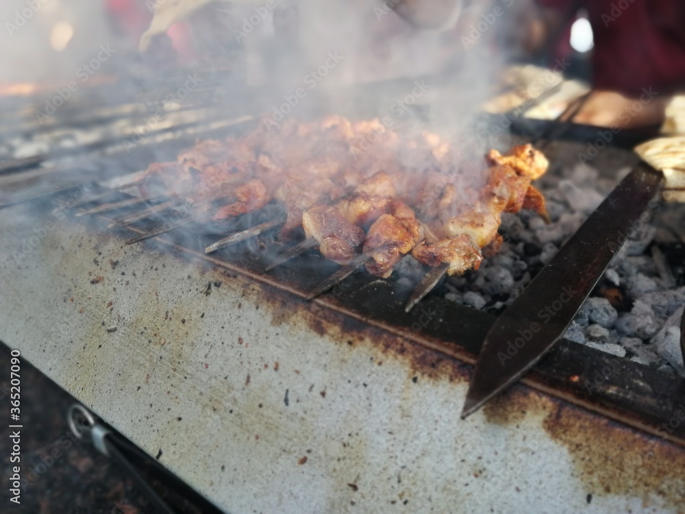 Shashlik preparing on a barbecue grill over charcoal. Shashlik or Shish kebab popular in Eastern Europe. Shashlik preparing on a barbecue grill over charcoal. Shashlik or Shish kebab popular in Eastern Europe.