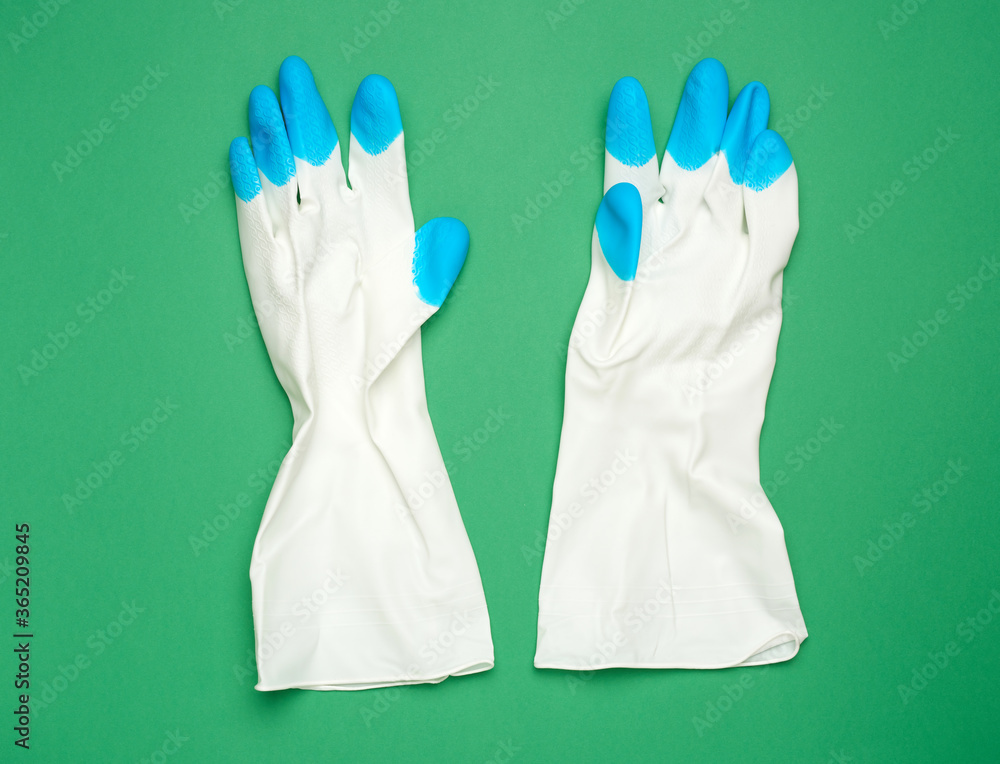 Fototapeta premium white protective rubber gloves on a green background