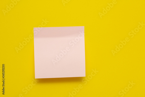 Pink sticker on a yellow background. Sticker with a sticky edge. Sticker for inscriptions. Copy space.
