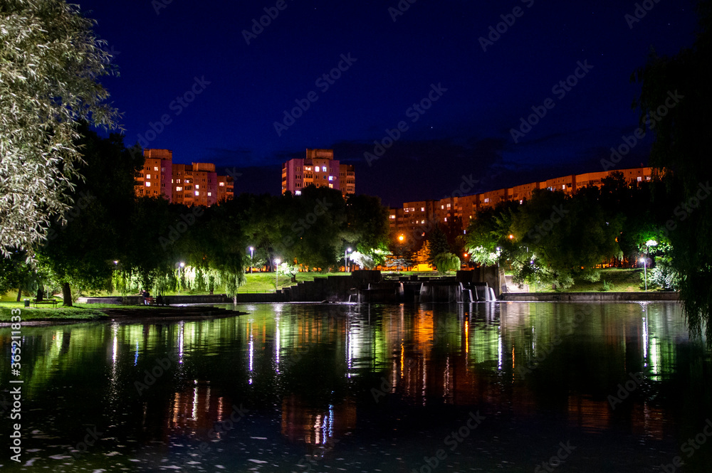 Night city park with a river and beautiful lanterns in summer